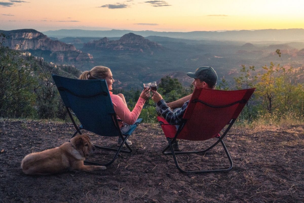 two people on camping folding chairs watching the sunset