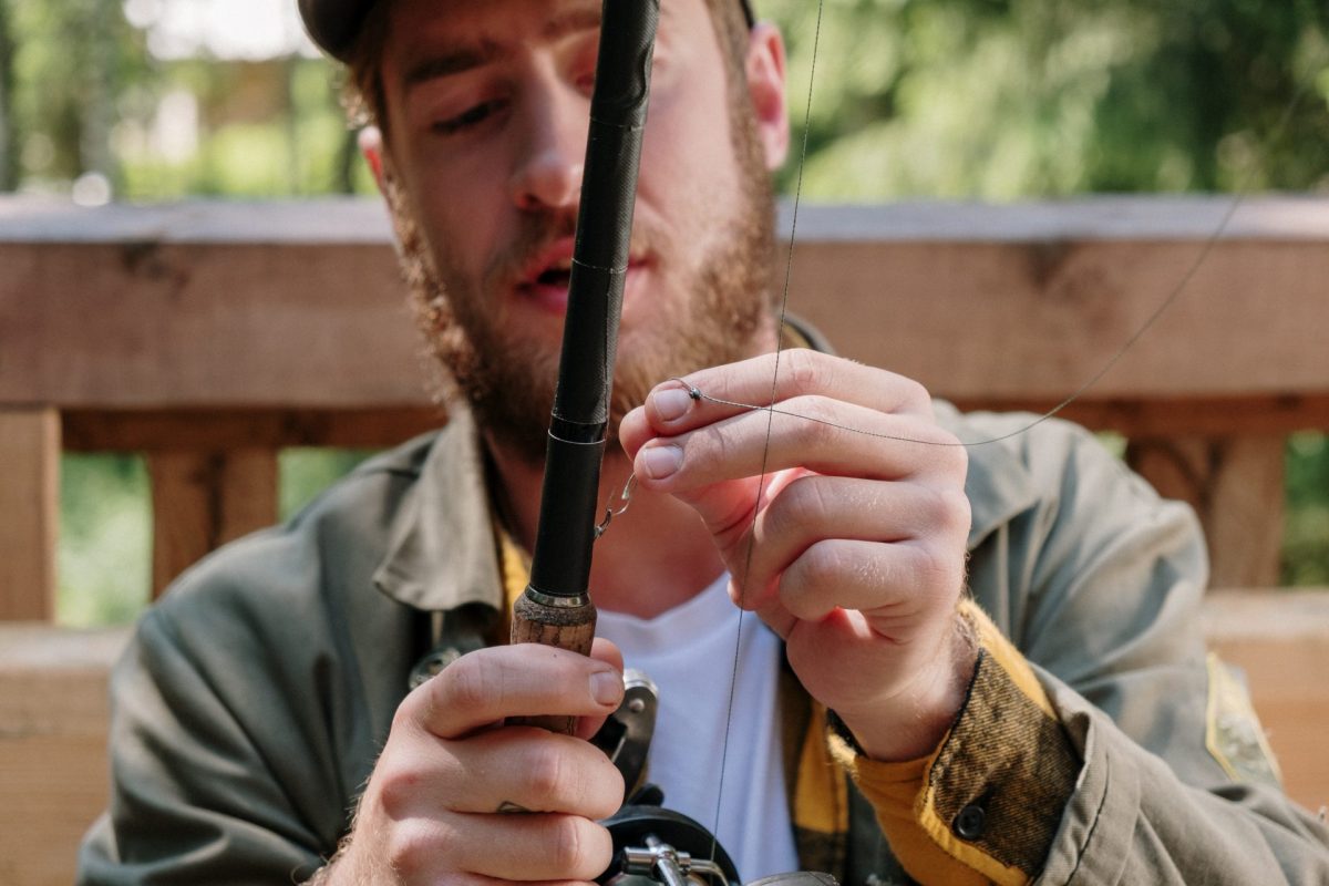 man tying fishing hook
